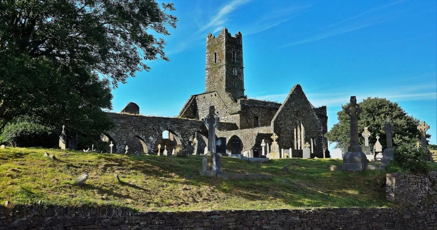 a stone church sitting on top of a lush green hillside, by Edward Corbett, flickr, romanesque, ruined buildings, holy cross, trinity, is a stunning