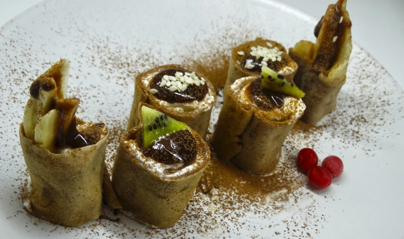 a close up of a plate of food on a table, inspired by Géza Dósa, chocolate sauce, kiwi, scrolls, sand