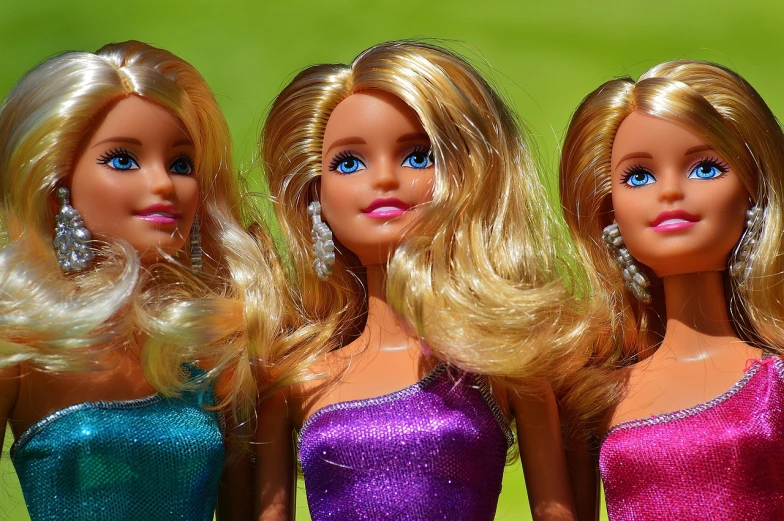 a group of three barbie dolls standing next to each other, a picture, by Mario Bardi, pixabay, flipped out hair, blonde - haired princess, sunny day time, toy photo