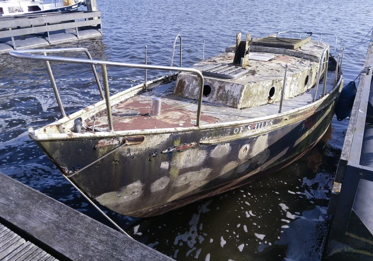 a rusty boat sitting on top of a body of water, a photo, by Richard Carline, auto-destructive art, he's on an old sailing boat, anato finnstark. front view, docked at harbor, above side view