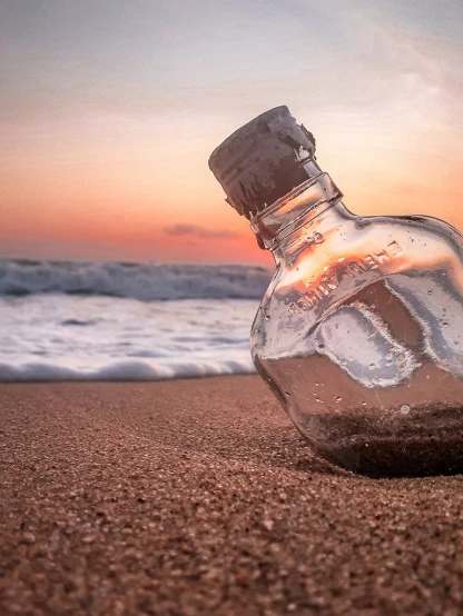 a glass bottle sitting on top of a sandy beach, a picture, by Jason Felix, pexels, conceptual art, sunset + hdri, set sail, realistic composition, istockphoto