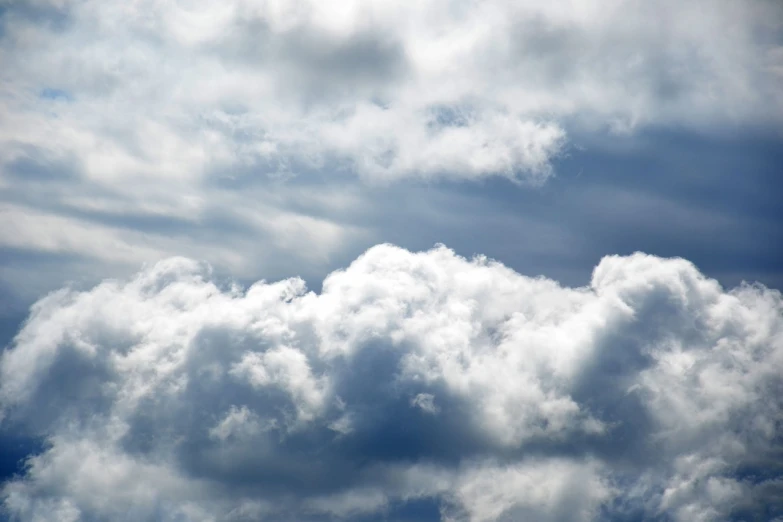 a plane flying through a cloudy blue sky, by Andrew Domachowski, romanticism, background full of stormy clouds, close up angle, whorl. clouds, version 3