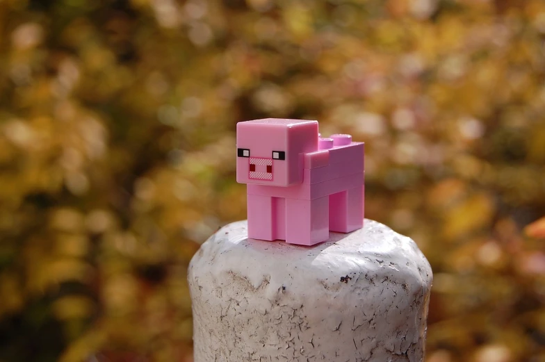 a pink pig sitting on top of a cement block, a picture, by Niko Henrichon, unsplash, pixel art, minecraft build, pvc figurine, pale - skinned, vertical wallpaper