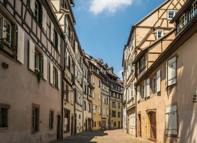 a cobblestone street in an old european city, a photo, by Juergen von Huendeberg, shutterstock, in nazi occupied france, sunny summer day, wooden houses, 12mm wide-angle