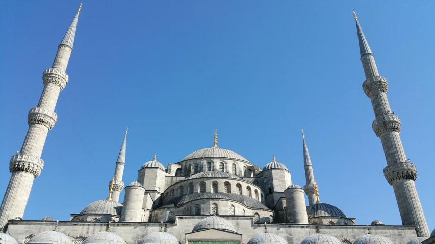 a group of people standing in front of a large building, a picture, inspired by Lü Ji, flickr, hurufiyya, clear blue skies, istanbul, dome, photo of a beautiful