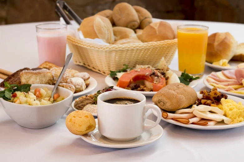 a table topped with plates of food and a cup of coffee, by Juan O'Gorman, shutterstock, breakfast buffet, bread, high quality product image”