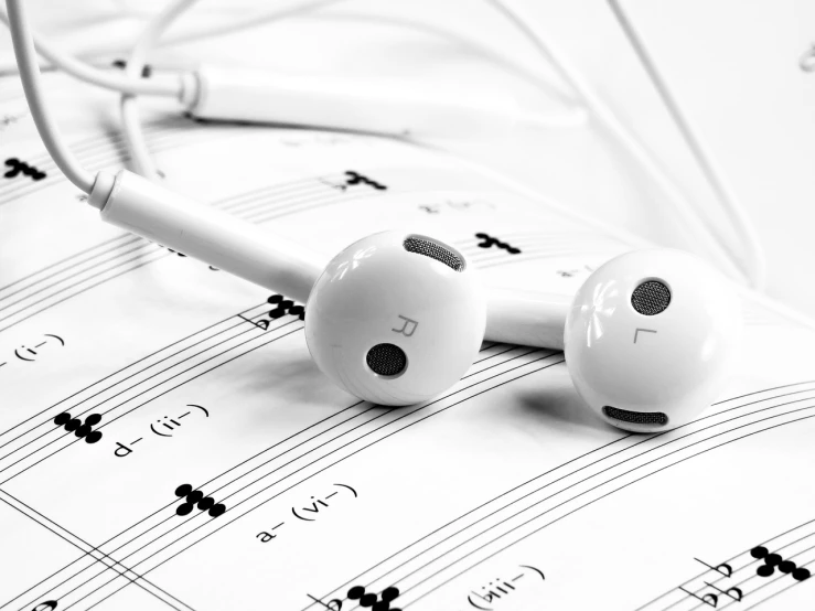 a pair of headphones sitting on top of a sheet of music, by Mirko Rački, trending on pixabay, glossy white, notation, pure b&w, earbuds