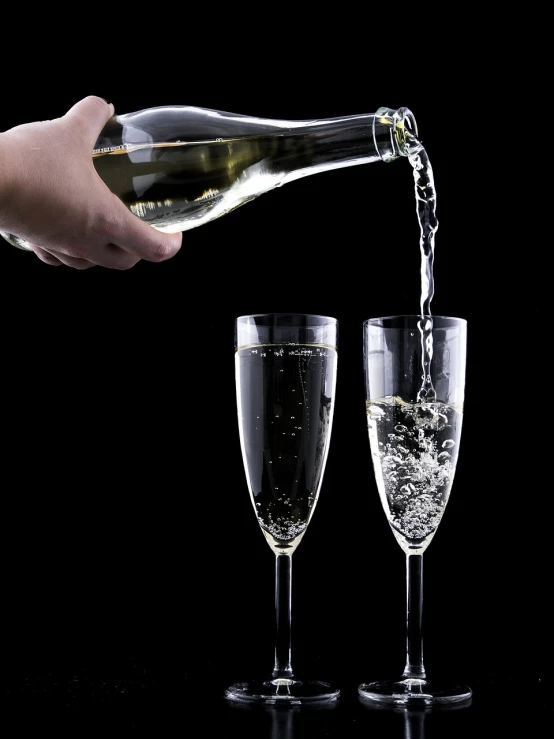 a person pouring a glass of wine into two glasses, by John Murdoch, shutterstock, minimalism, lots of bubbles, on black background, high detail product photo, champagne commercial