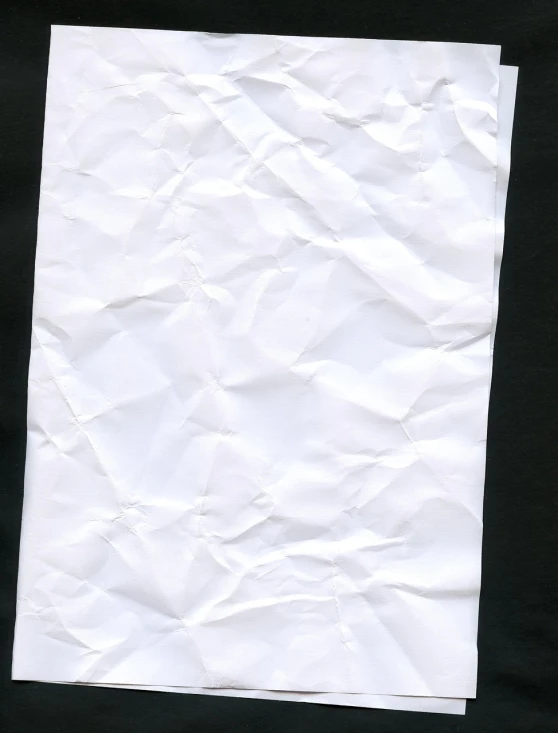 a piece of white paper sitting on top of a table, inspired by Masamitsu Ōta, reddit, minimalism, black background!!!!!, wrinkled, high res photo, back facing