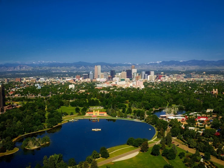 a view of a city from a bird's eye view, by Paul Emmert, shutterstock, rocky mountains in background, parks and lakes, capital plaza, “wide shot