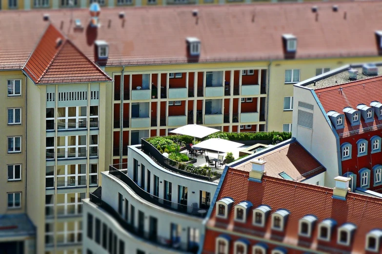 a group of buildings that are next to each other, a tilt shift photo, by Ulrich Leman, roof garden, post processed, terrace, depth of field”