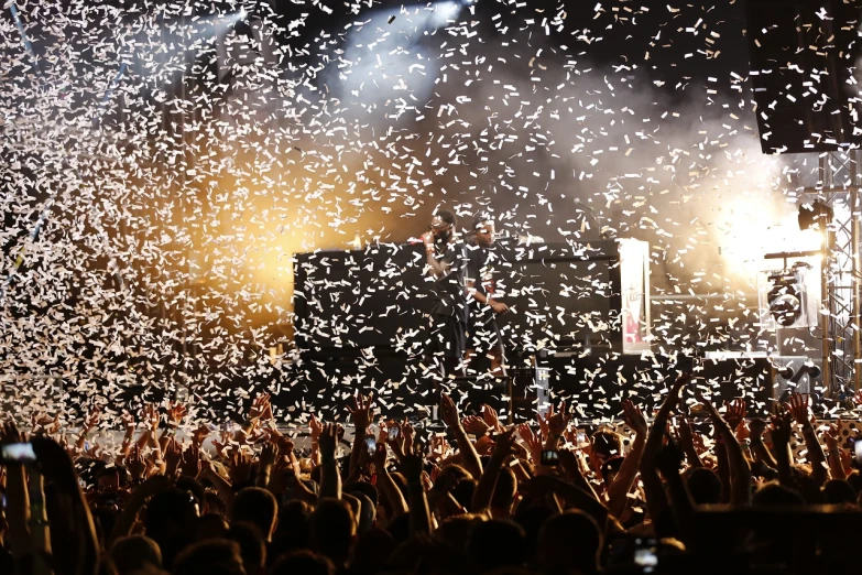 a crowd of people at a concert with confetti falling from the sky, a picture, figuration libre, orelsan, heavy metal concert, tim booth, rapping on stage at festival