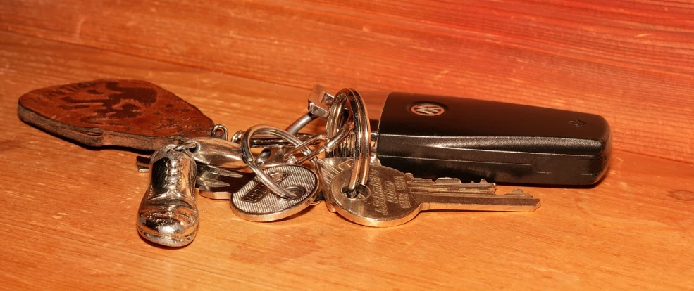 a bunch of keys sitting on top of a wooden table, a stock photo, by Tom Carapic, mid morning lighting, moderately detailed, terminals, older male