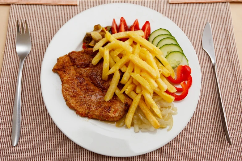 a white plate topped with french fries and vegetables, a picture, shutterstock, slavic!!!, pork meat, gradins view, qiangshu