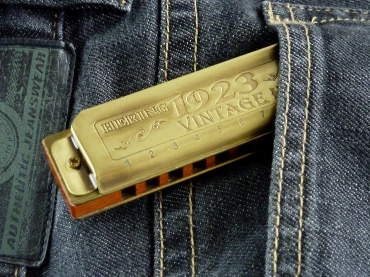 a harmonica in the pocket of a pair of jeans, by Joe Machine, bauhaus, roaring twenties, more details, brass plates, vtm