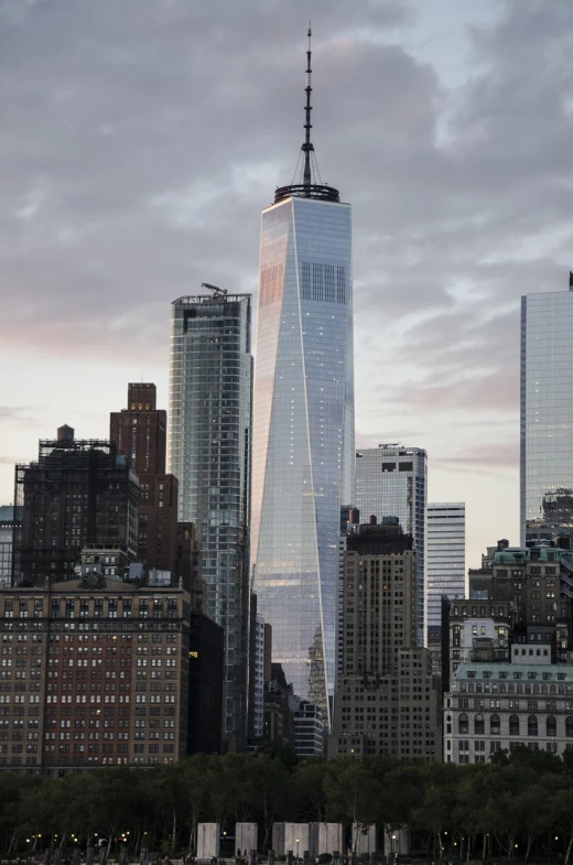 a very tall building sitting in the middle of a city, a picture, by Joseph Pisani, daniel libeskind, new york skyline, close up shot from the side, at dawn