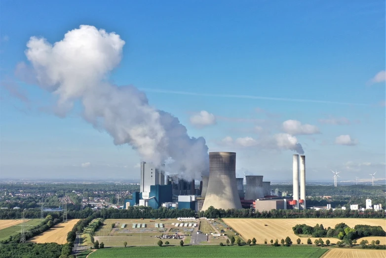 a factory with a lot of smoke coming out of it, a picture, by Werner Gutzeit, shutterstock, coal, photo taken from far away, electrical plant location, shot from drone