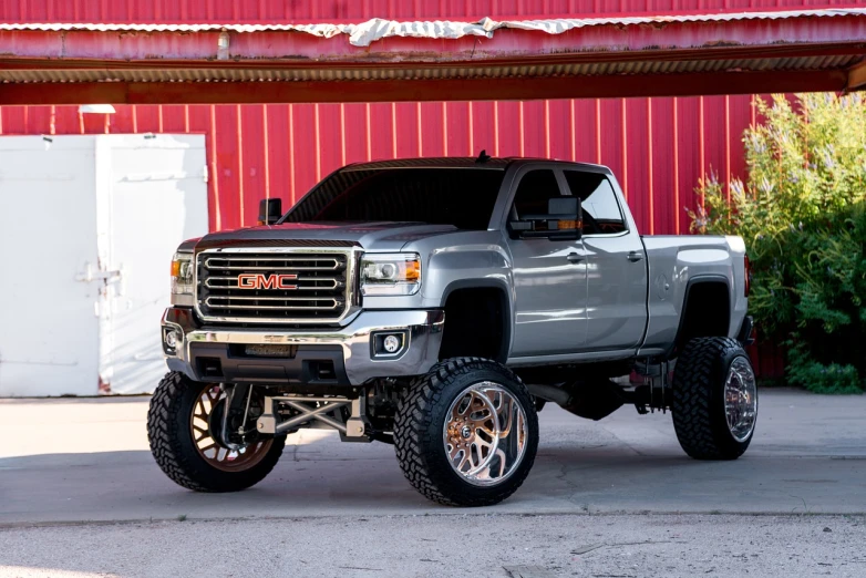 a silver truck parked in front of a red building, inspired by Drew Tucker, featured on instagram, renaissance, detailed alloy wheels, gm, full body shot close up, redneck country