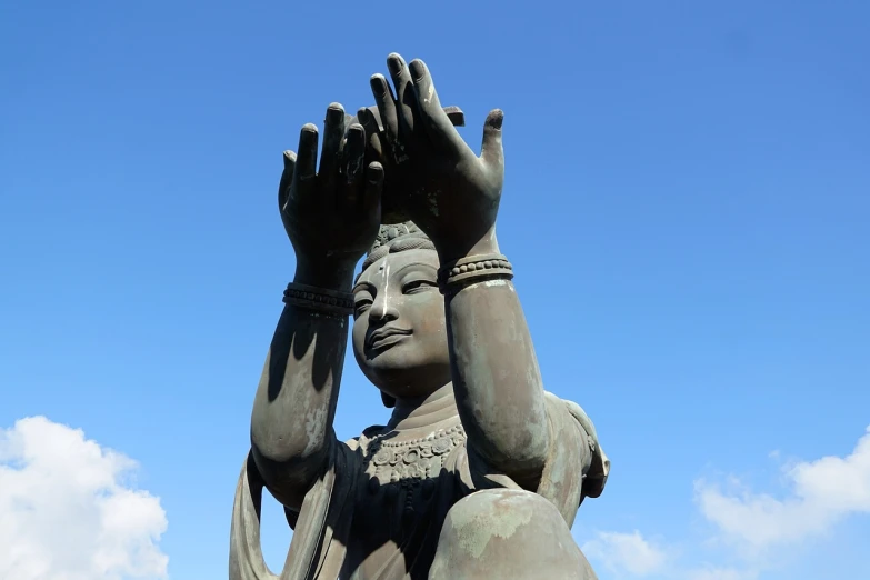 a statue of a woman holding her hands up, a statue, shutterstock, japan shonan enoshima, hinduism, shot from a low angle, very high detail