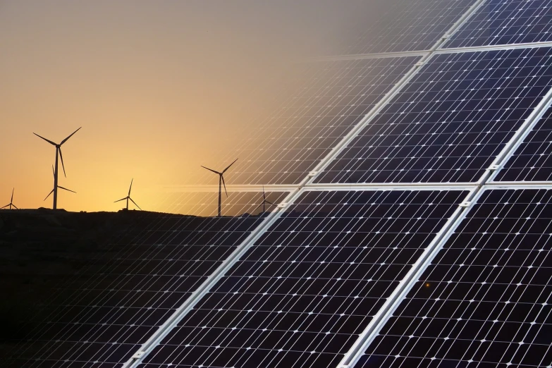 a row of solar panels with wind turbines in the background, a picture, by Carey Morris, pexels, dawn and dusk, grid and web, bottom angle, jacqueline e