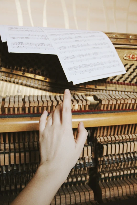 a person touching a sheet of music on top of a piano, musical organ, straw, tuning, panels