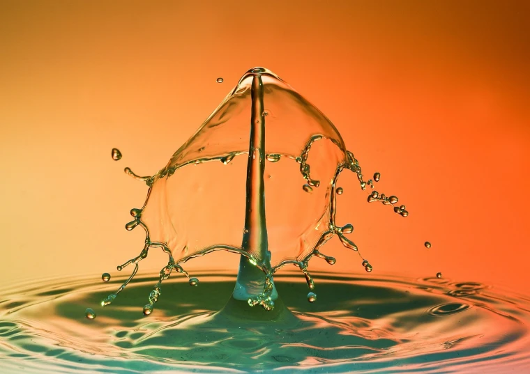 a splash of water on top of a body of water, by Jan Rustem, shutterstock, art photography, in front of an orange background, hdr photography, stock photo, liquid sculpture