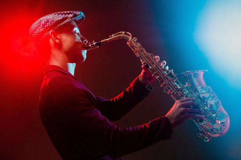 a man with a hat playing a saxophone, by Adam Marczyński, shutterstock, blue and red lighting, live performance, ivan shishk, recreation