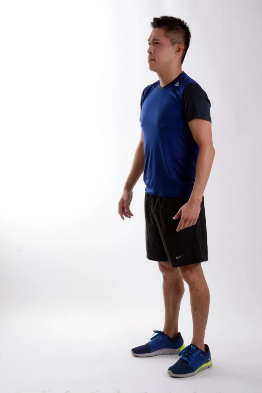 a man in a blue shirt and black shorts, pexels, shin hanga, wearing fitness gear, standing posture, fullbody photo