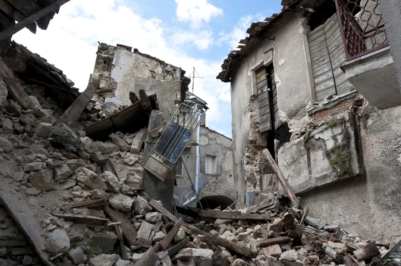 a pile of rubble sitting in front of a building, a photo, by Alessandro Galli Bibiena, shutterstock, quake, seen from below, village, 2 0 1 0 photo