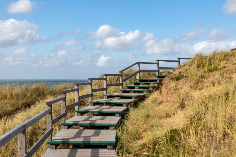 a set of stairs going up the side of a hill, a stock photo, by Niels Lergaard, shutterstock, dunes in the background, near a jetty, unwind!, abcdefghijklmnopqrstuvwxyz