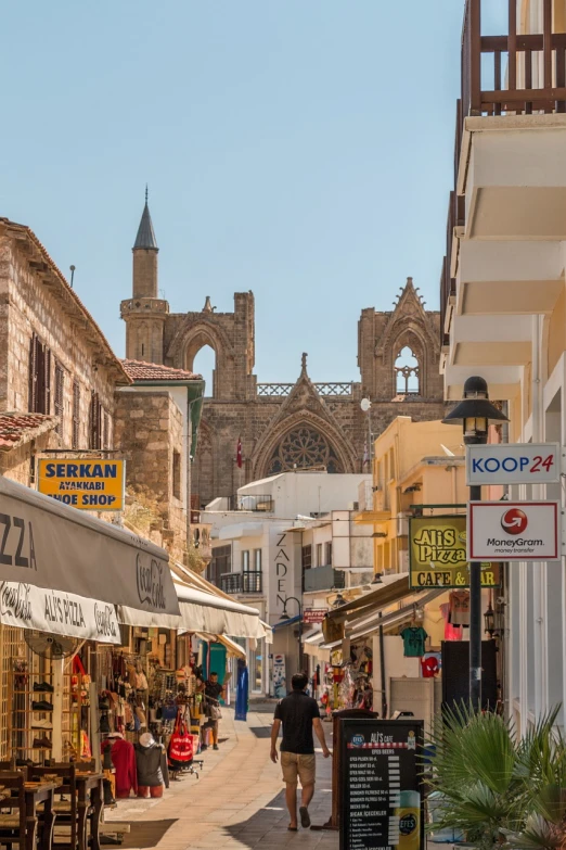 a couple of people that are walking down a street, a photo, by David Garner, shutterstock, renaissance, cyprus, tall stone spires, market stalls, viewed from the harbor