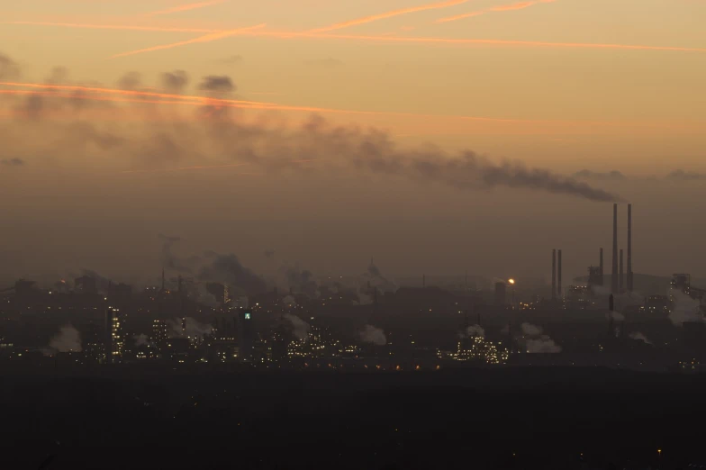 a city with a lot of smoke coming out of it, a picture, by Werner Gutzeit, dawn setting, industry, 2 0 0 mm wide shot, january 20th