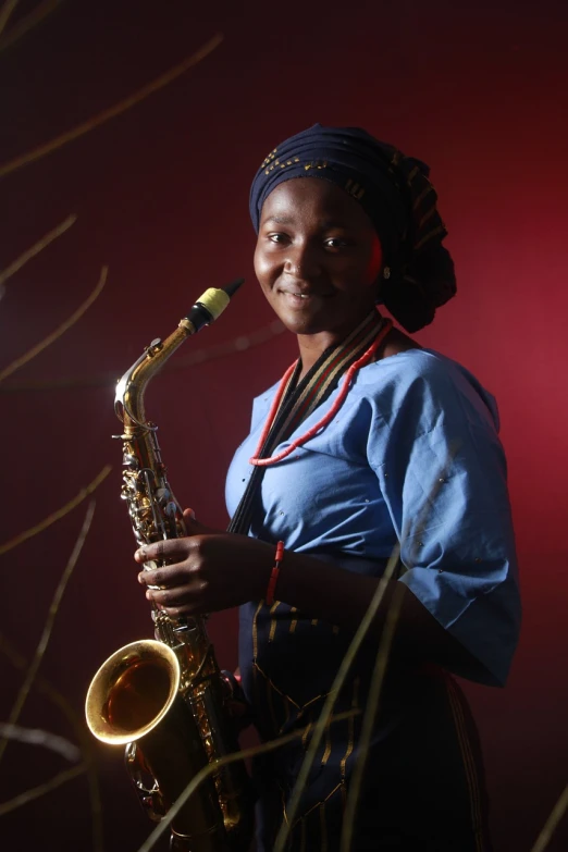 a woman in a blue dress playing a saxophone, by Ella Guru, in style of nadine ijewere, studio portrait, age 2 0, local close up