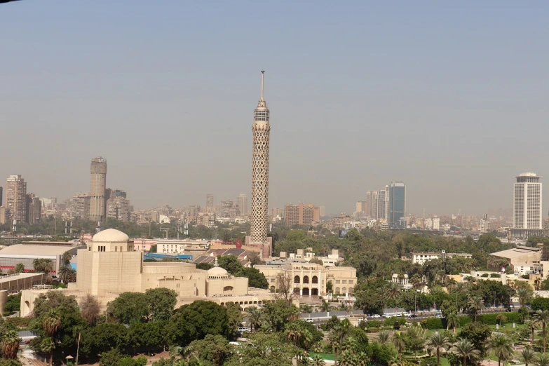 a view of a large city with tall buildings, a picture, by Ahmed Karahisari, flickr, hurufiyya, nefertiti, neoclassical tower with dome, brutalist buildings tower over, cone