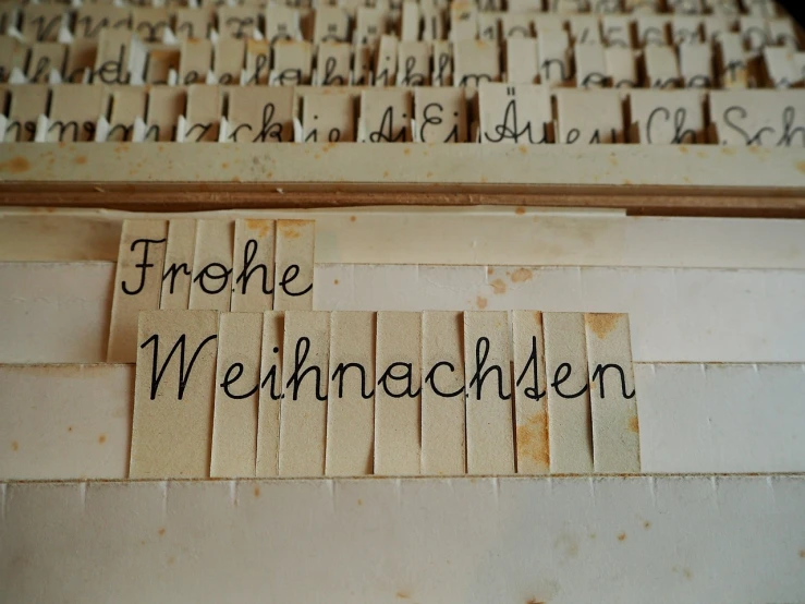 a close up of a keyboard with writing on it, a photo, by Marion Wachtel, viennese actionism, paper decoration, holiday, german, handmade