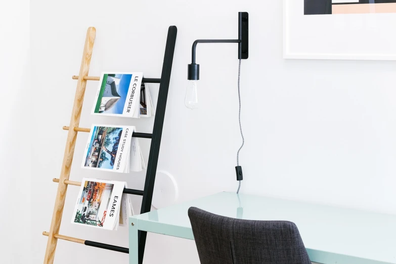 a ladder leaning against a wall next to a desk, magazines, vanta black, clean image, 3 / 4 view