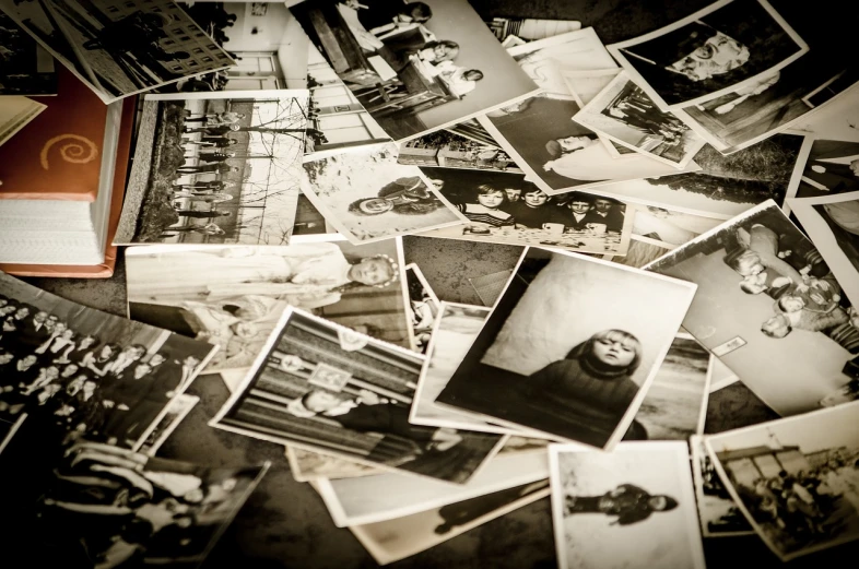 a pile of old photos sitting on top of a table, a black and white photo, process art, on flickr in 2007, portrait!!, having a good time, ww2 historical photo