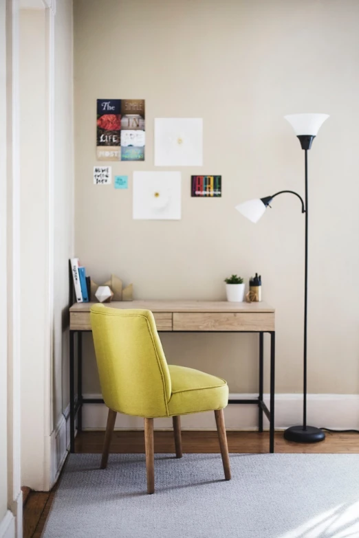 a yellow chair sitting in front of a desk, a picture, light and space, listing image, lamps, wall full of small art painting, reading nook