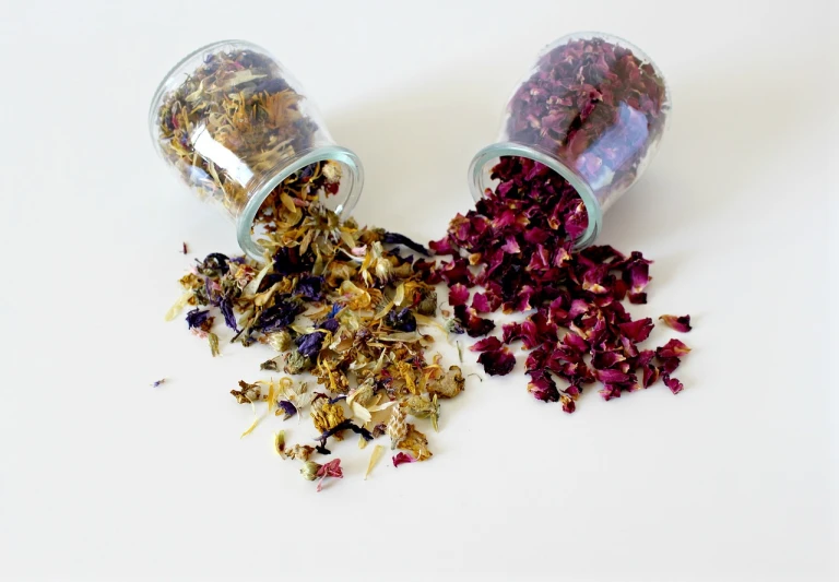 a couple of jars filled with dried flowers, by Rhea Carmi, mixing, sparkling petals, high quality product photo, viridian and venetian red