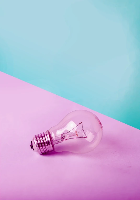 a light bulb sitting on top of a pink and blue surface, a stock photo, realism, violet colored theme, on a bright day, playful composition canon, halogen