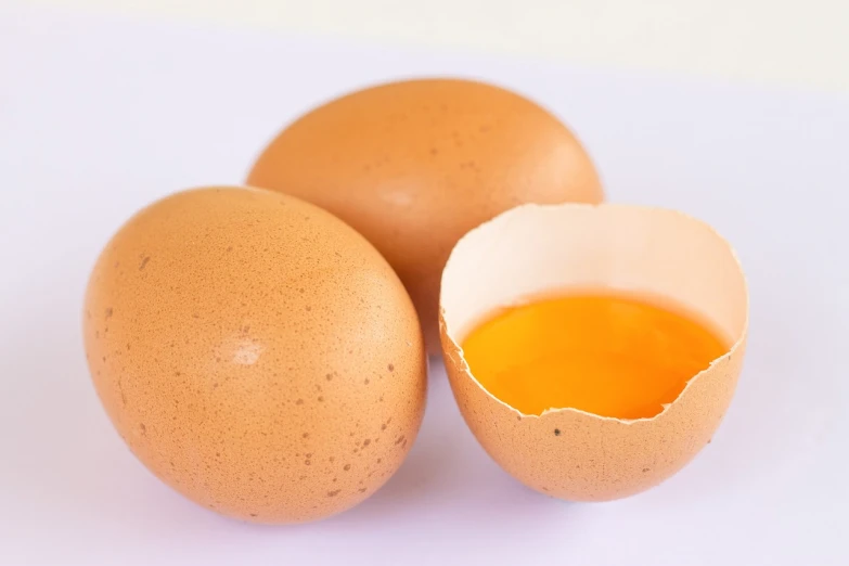 three eggs sitting next to each other on a white surface, by Yi Jaegwan, shutterstock, cooking oil, 38 years old, close-up product photo, gape