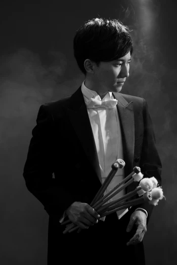 a man in a tuxedo holding a bunch of flowers, inspired by Yousuf Karsh, jaeyeon nam, the last orchestra, b&w photo, mist