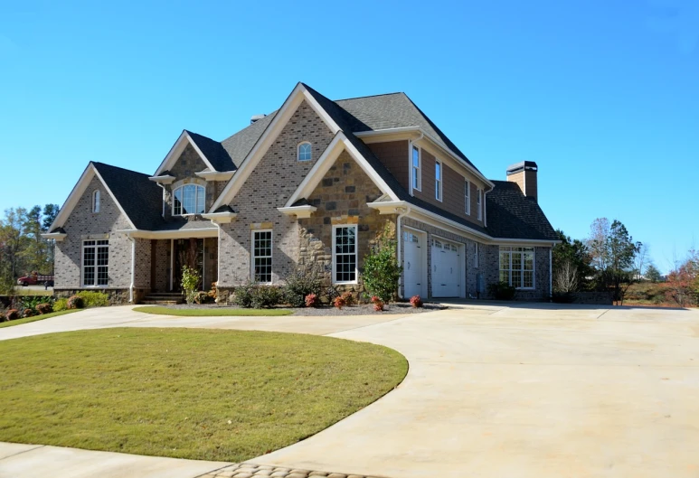 a large house sitting on top of a lush green field, pixabay, modernism, driveway, stone, front elevation view, perfect crisp sunlight