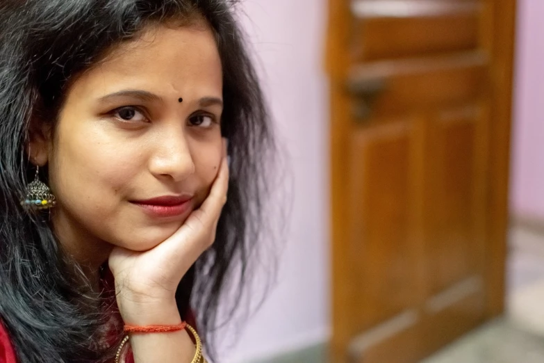 a close up of a person with a cell phone, inspired by Sunil Das, hand on her chin, home photography portrait, friedly smile, 3 / 4 view portrait