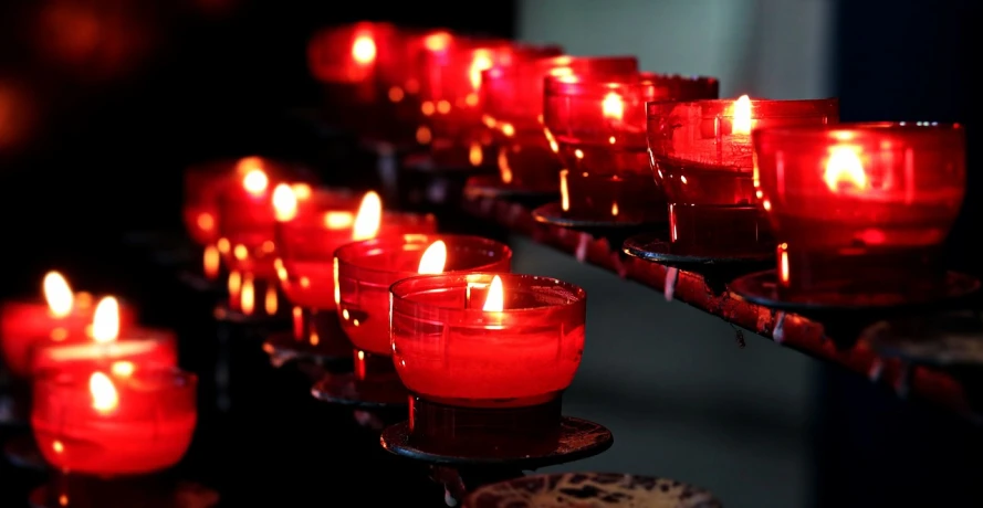 a row of red candles sitting on top of a table, avatar image, pray, red neon, beautiful image