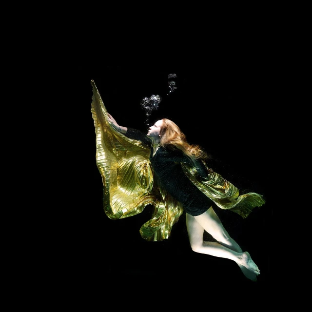 a woman flying through the air in a green dress, a portrait, by Harvey Pratt, unsplash, renaissance, golden fish in water exoskeleton, on deep black velvet, golden robes, swimming underwater