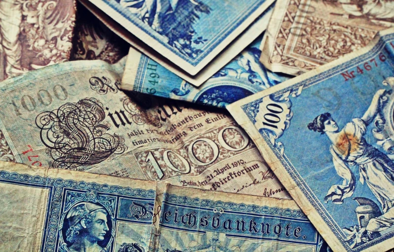 a pile of old currency sitting on top of a table, by Micha Klein, trending on pixabay, baroque, jugendstil background, mobile wallpaper, set in ww2 germany, vintage - w 1 0 2 4