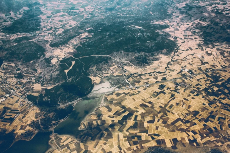 an aerial view of a city and a body of water, a picture, regionalism, dry landscape, view from above from plane, swedish countryside, medium contrast