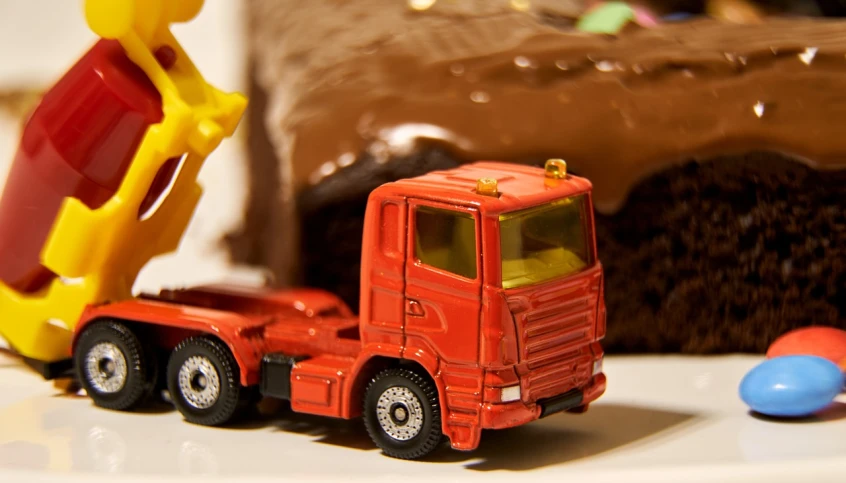 a close up of a toy truck near a cake, by Romain brook, figuration libre, image dataset, chocolate, from transformers, traffic