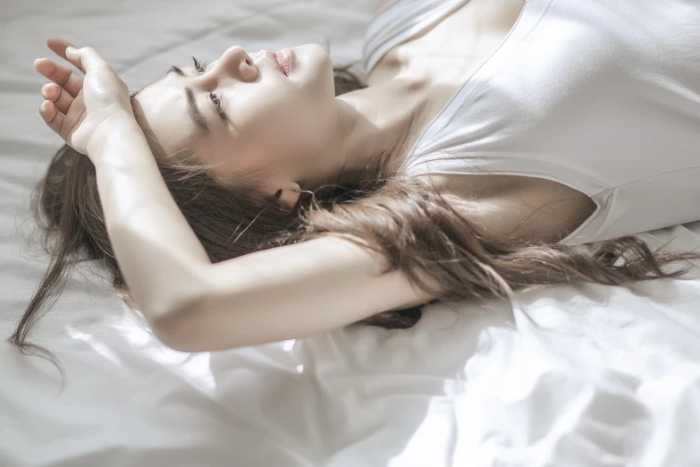 a beautiful young woman laying on top of a bed, a stock photo, by Shitao, tumblr, exquisite and smooth detail, morning lighting, side-view, waist - shot